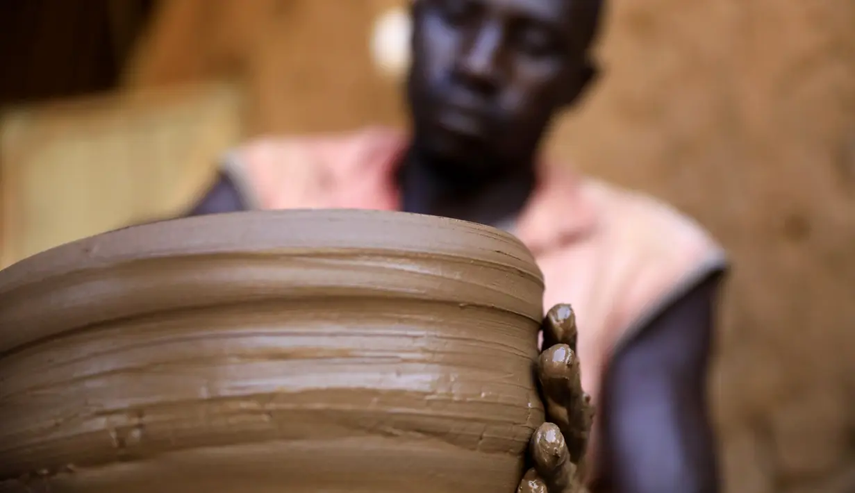 Seorang perajin Sudan membuat barang-barang tembikar di Khartoum, Sudan (20/10/2020). Para perajin tembikar di Sudan memanfaatkan tanah liat sisa banjir untuk membuat benda-benda kerajinan tersebut. (Xinhua/Mohamed Khidir)