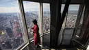 Seorang wanita menikmati pemandangan Kota Manhattan dari ruangan observatorium di lantai 102 Gedung Empire State yang baru direnovasi di New York (10/10/2019). Dibuka untuk umum pada 12 Oktober, ruang observatorium ini berjarak 1.250 kaki di atas permukaan jalan. (AFP Photo/Drew Angerer)