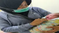 Bidan Siti Indriyani membantu ibu melahirkan di Pasar Pabean Surabaya, Jawa Timur. (Foto: Dok Koarmada 2 TNI AL)