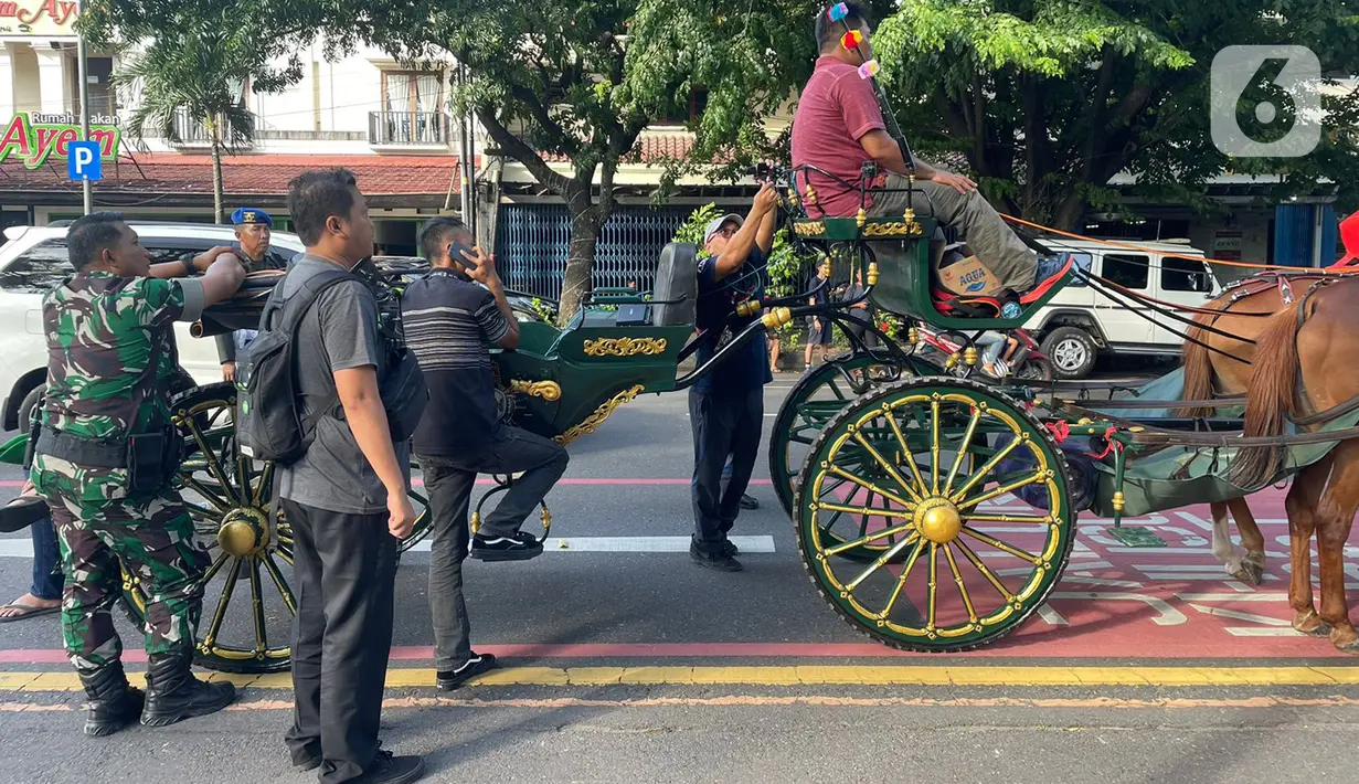 Petugas mempersiapkan kuda saat geladi bersih di kawasan Slamet Riyadi, Solo, Jawa Tengah, Sabtu (10/12/2022). Sebanyak 12 kereta kuda untuk cadangan, disiapkan untuk kirab ngunduh mantu pernikahan putra bungsu Presiden Joko Widodo, Kaesang Pangarep dengan Erina Gudono, Minggu (11/12) di Solo. (Liputan6.com/Herman Zahkaria)