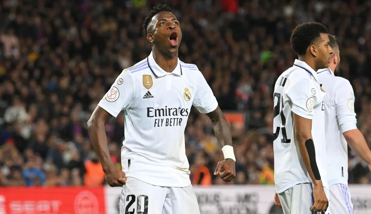 Selebrasi striker Real Madrid, Vinicius Junior setelah mencetak gol pertama timnya ke gawang Barcelona pada laga leg kedua semifinal Copa del Rey 2022/2023 di Camp Nou Stadium, Barcelona, Kamis (6/4/2023) dini hari WIB. (AFP/Lluis Gene)