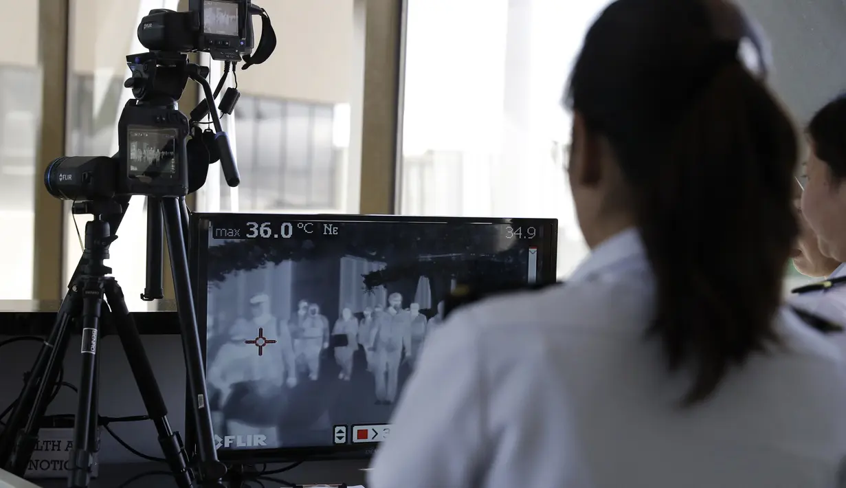 Petugas memindai suhu tubuh penumpang di bandara internasional Manila (23/1/2020). Ratusan orang dinyatakan positif terjangkit virus corona, dan Pemerintah Hubei di China mengkonfirmasi jumlah korban tewas melonjak dari 9 menjadi 17 lalu 26 orang hanya dalam beberapa jam. (AP Photo/Aaron Favila)