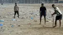 Sejumlah pemuda India bermain kriket dengan dipenuhi sampah plastik di pantai Juhu di Mumbai, (2/6). (AFP PHoto/Punit Paranjpe)