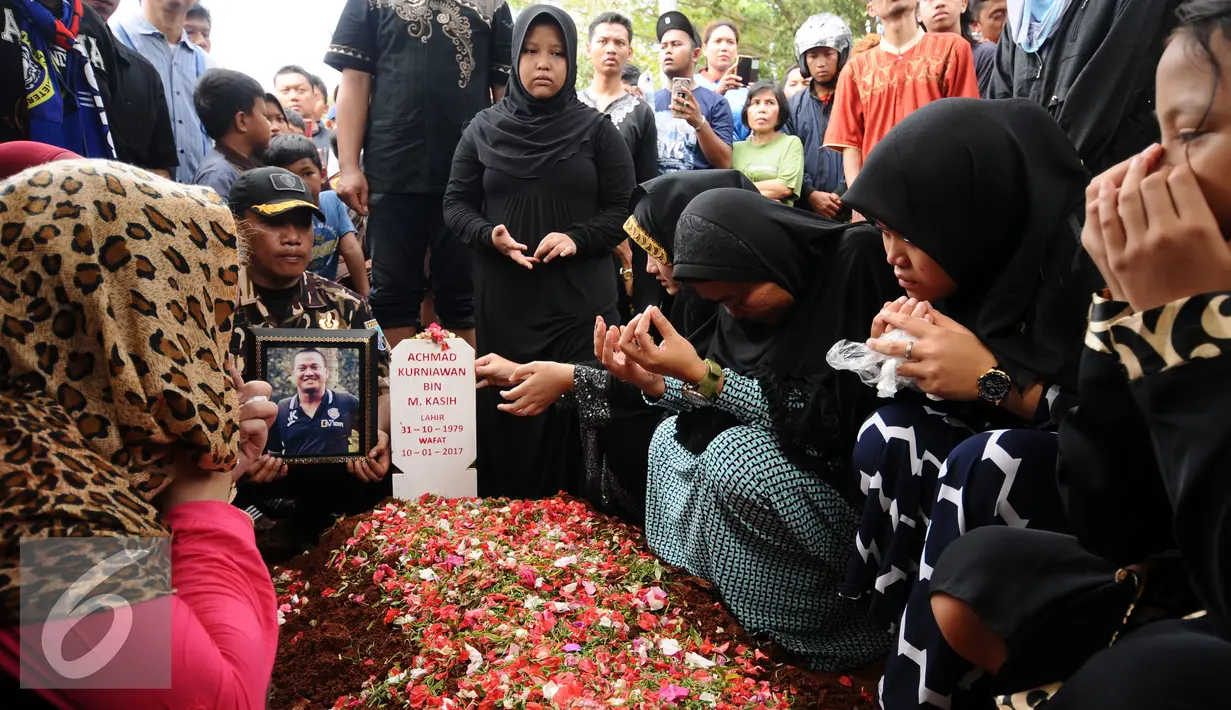 Keluarga berdoa di sisi makam Achmad Kurniawan di TPU Cijantung, Jakarta, Rabu (11/1). Kiper Arema FC, Achmad Kurniawan wafat di usia 37 tahun. (Liputan6.com/Helmi Fithriansyah)
