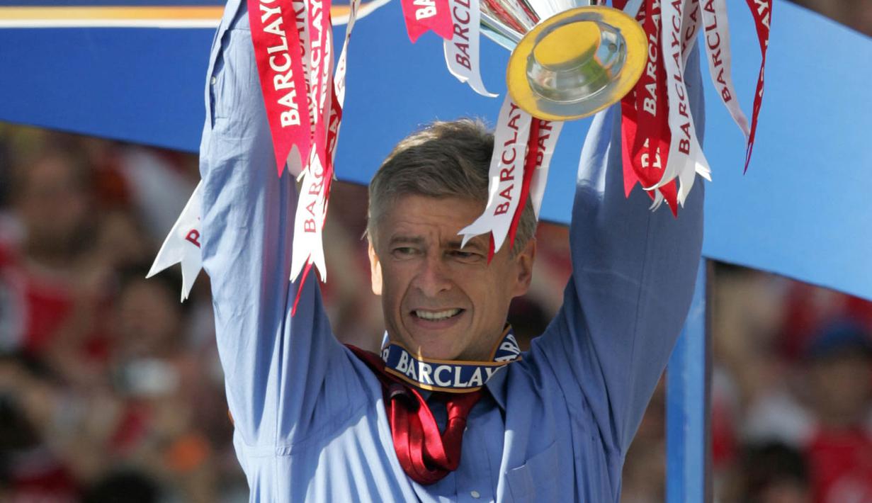 Pelatih Arsenal, Arsene Wenger, mengangkat trofi Premier League usai mengalahkan Leicester di Stadion Highbury, London, Minggu (15/5/2004). (AFP/Jim Watson)