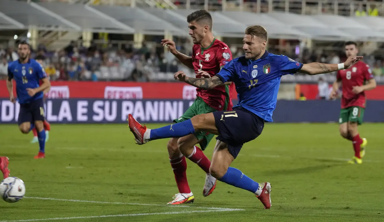 Pemain Italia Ciro Immobile (kanan) melakukan tembakan ke gawang di depan pemain Bulgaria Petko Hristov pada pertandingan sepak bola Grup C kualifikasi Piala Dunia 2022 di Stadion Artemio Franchi, Florence, Italia, Kamis (2/9/2021). Pertandingan berakhir dengan skor 1-1. (AP Photo/Luca Bruno)