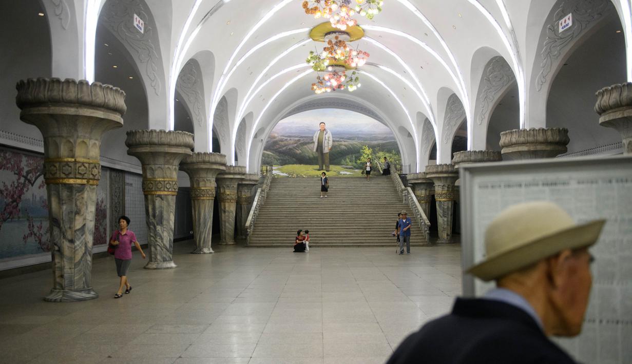 Seorang komuter membaca koran pada platform stasiun kereta bawah tanah atau metro Pyongyang, 6 September 2018. Stasiun bawah tanah Pyongyang terkesan megah dan bersih, tak seperti yang dibayangkan kebanyakan orang. (AFP / Ed JONES)