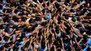 Pemuda India membentuk piramida manusia dalam perayaan Festival Janmashtami di Mumbai, Senin (3/9). Piramida manusia itu dibentuk untuk memecahkan pot berisikan susu yang menggantung di langit-langit rumah supaya bisa diambil isinya. (AP/Rafiq Maqbool)