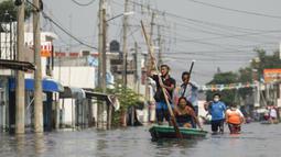 Warga naik perahu di jalan-jalan Villahermosa, Meksiko, Rabu (11/11/2020). Banjir mengakibatkan hampir 10.000 orang ke tempat penampungan dan menewaskan sebanyak lima orang. (AP Photo/Felix Marquez)