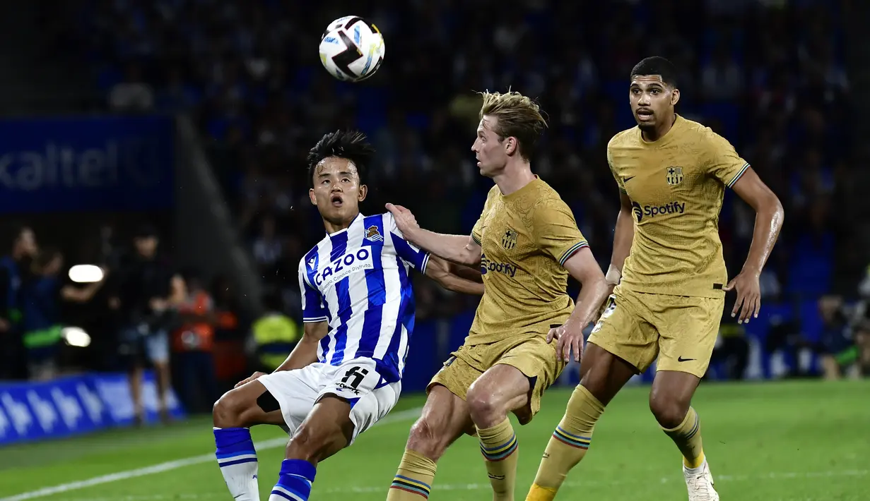 Gelandang Real Sociedad Takefusa Kubo berebut bola dengan gelandang Barcelona Frenkie de Jong dalam lanjutan LaLiga 2022/2023 di Reale Seguros Stadium, San Sebastian, Sein (22/8/2022) dini hari WIB. Barcelona mempermalukan tuan rumah Real Sociedad 4-1 berkat dua gol penyerang anyar Robert Lewandowski. (AP Photo/Alvaro Barrientos)