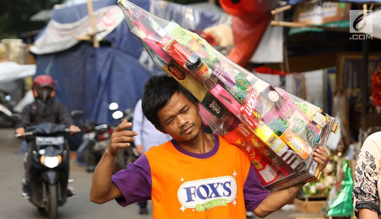 Pedagang membawa parsel yang dijual di kawasan Cikini, Jakarta, Rabu (6/6). Menjelang Hari Raya Idul Fitri, penjualan parsel para pedagang dadakan tersebut meningkat hingga 50 persen. (Liputan6.com/Immanuel Antonius)