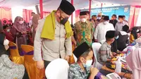 Kapolda Riau melihat santri yang mengikuti vaksinasi massal memperingati Hari Santri Nasional di Kabupaten Kampar. (Liputan6.com/M Syukur)