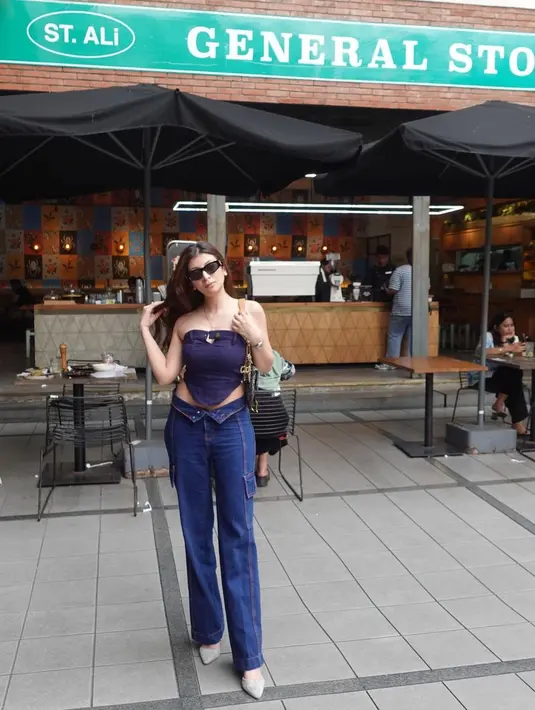 Gaya edgy denim on denim ala Sarah Keihl. Ia kembali mengenakan cropped top tanpa tali dan lengan dari denim berwarna biru, dipadunya celana jeans pipa dengan kantong di sisi kanan-kirinya. [Foto: Instagram/sarahkeihl]