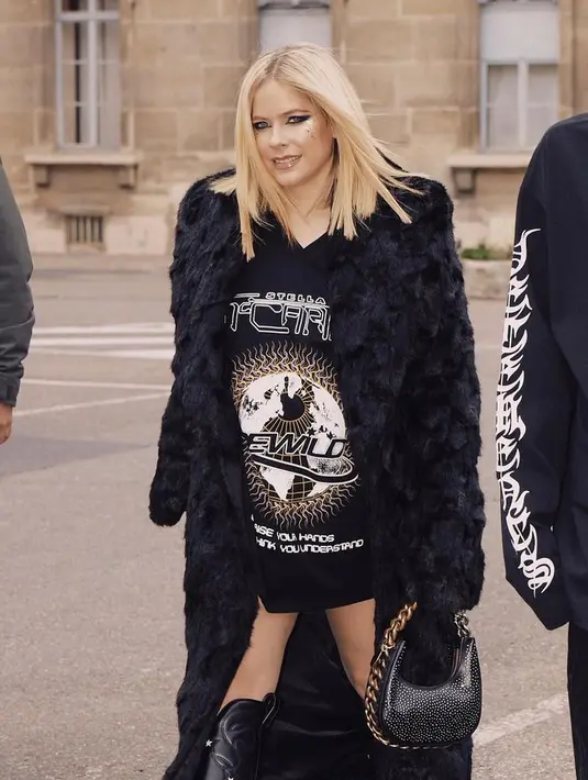 Avril Lavigne ikut berpakaian tanpa celana dalam T-shirt grafis dan sepatu boot di Paris Fashion Week. [@avrillavigne]