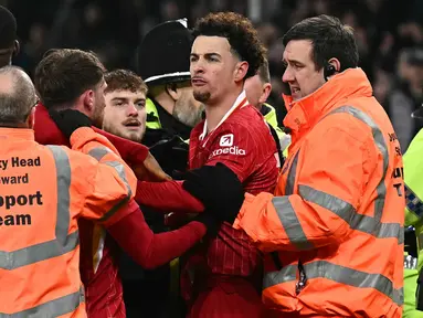 Pemain Liverpool, Curtis Jones berusaha dipisahkan saat terlibat perseteruan dengan pemain Everton, Abdoulaye Doucoure setelah laga lanjutan Liga Inggris 2024/2025 di Goodison Park, Liverpool, Inggris, Rabu (13/02/2025) WIB. (AFP/Paul Ellis)