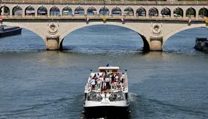 Kapal melewati&nbsp;sepanjang Sungai Seine di Paris pada 4 Juli 2024. (Dok: JOEL SAGET / AF)