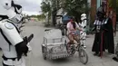 Anggota kelompok pemuda dalam kostum Star Wars menghibur warga di Malabon, Metro Manila, Filipina, Kamis (30/4/2020). Kelompok pemuda berkostum Star Wars menghibur warga selama karantina berkelanjutan akibat COVID-19 serta mengingatkan mereka agar tetap di rumah. (AP Photo/Aaron Favila)