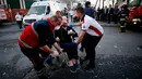 Petugas medis mengevakuasi seorang pasien setelah terjadi kebakaran di rumah sakit di distrik Gaziosmanpasa, Istanbul, Turki (5/4). Sebanyak 70 pasien dievakuasi dari peristiwa ini. (AP Photo/ Emrah Gurel)