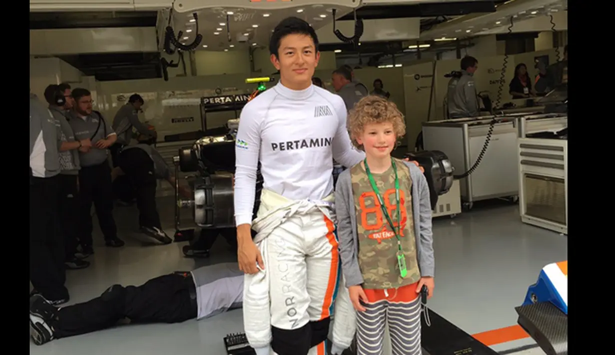 Pebalap Manor Racing asal Indonesia, Rio Haryanto, bersama penggemar ciliknya, Milo, jelang kualifikasi F1 GP China di Sirkuit Internasional Shanghai, China, Sabtu (16/4/2016). (Bola.com/Twitter/Manorracing)