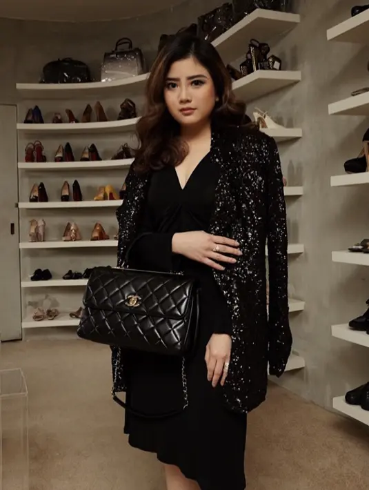 Tampil serba hitam, ia tampak anggun dengan dress hitam longslevee berdada rendah, dipadukan cardigan berkilau. Tas Chanel hitam pun melengkapi penampilannya. @valenciatanoe