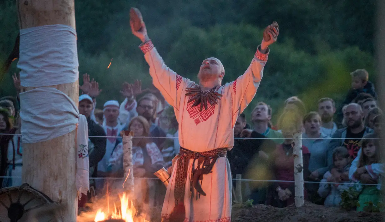 Seorang pria memimpin upacara ritual pagan kuno di dekat desa Glubokovo, Rusia (24/6). Ritual ini diyakini sebagai salah satu ritual tertua di dunia. (AFP Photo/Andrei Borodulin)