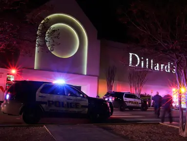 Polisi San Antonio berjaga di pintu keluar setelah terjadinya baku tembak di Rolling Oaks Mall, Texas, Minggu (22/1). Satu orang tewas dan tujuh orang lainnya mengalami luka tembak, termasuk salah satu tersangka. (AP Photo/Eric Gay)