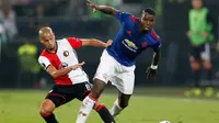 Gelandang Manchester United Paul Pogba berebut bola dengan pemain Feyenoord Karim El Ahmadi pada laga Liga Europa di De Kuip, Rotterdam, Kamis (15/9/2016) atau Jumat dini hari WIB. (Reuters/Matthew Childs)