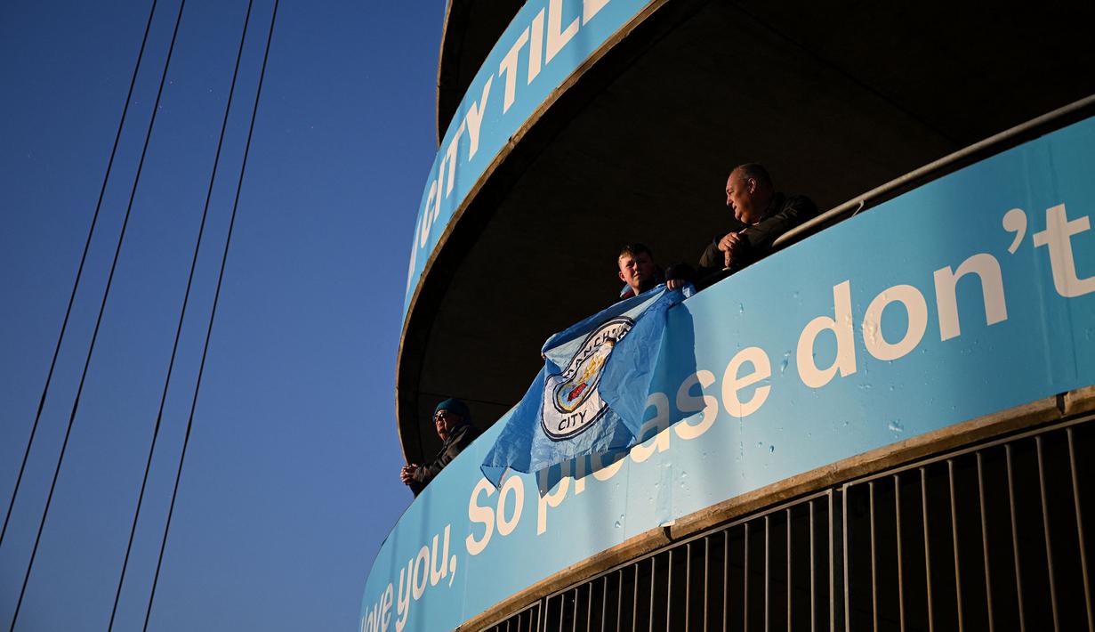 Pendukung Manchester City membentangkan bendera dalam laga lanjutan Liga Inggris 2024/2025 di Etihad Stadium, Manchester, Inggris, Rabu (02/04/2025) waktu setempat. (AFP/Oli Scarff)
