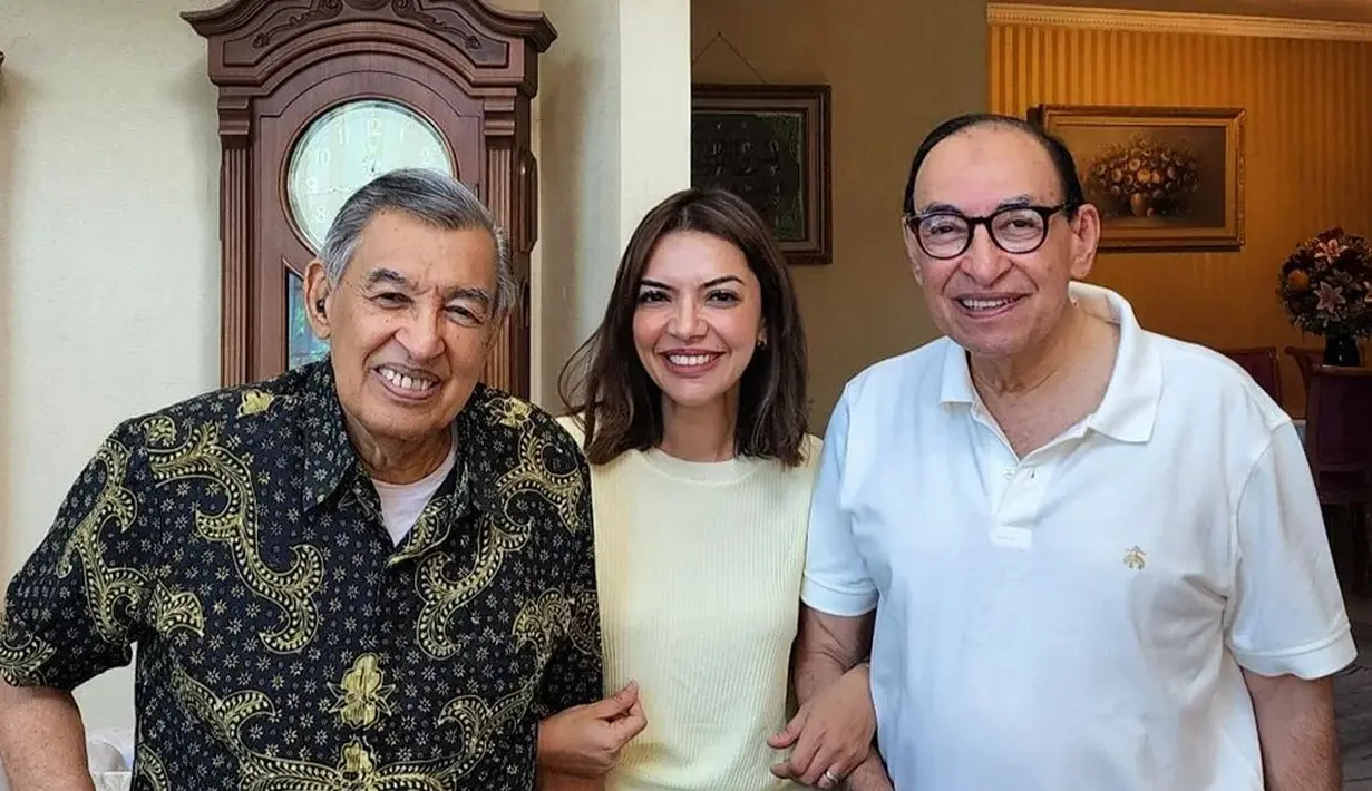 Potret manis Najwa Shihab menggandeng sang abi Quraish Shihab dan pamannya. Tampil sederhana dengan knitted top berwarna broken white dipadu dengan celana jeans. Foto: Instagram.