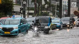 Sejumlah kendaraan melintas menerjang genangan air di kawasan Bunderan HI, Jakarta, Kamis (22/11). Genangan air hujan setinggi 40 cm tersebut disebabkan hujan deras yang melanda Jakarta pada siang hari. (Liputan6.com/Faizal Fanani)