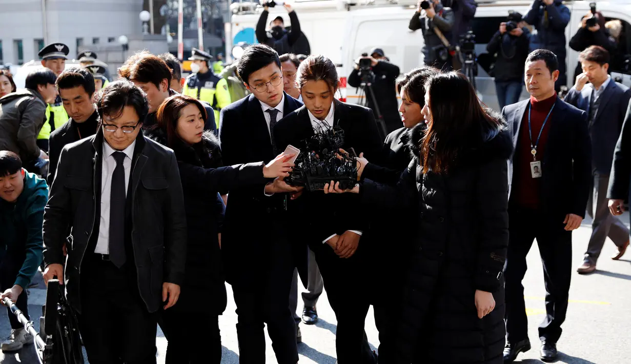 Penyanyi Korea Selatan, Jung Joon Young menjawab pertanyaan wartawan setibanya di Kantor Polisi Metro Seoul, Kamis (14/3). Jung Joon Young dituduh melakukan rekaman  secara ilegal dan membagikannya di media sosial. (REUTERS/Kim Hong-Ji)