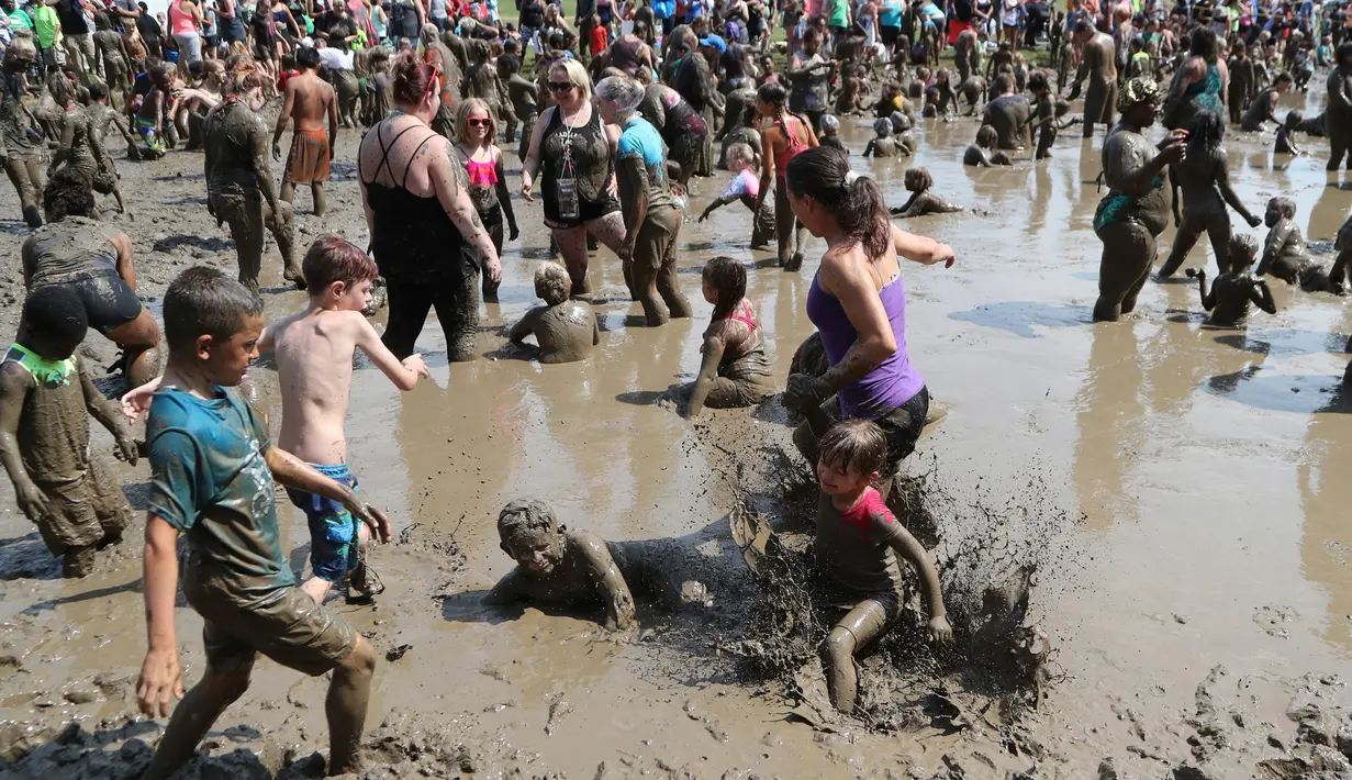 Ratusan anak bermain dalam kubangan berisi lumpur saat perayaan Mud Day atau Hari Lumpur Tahunan di Westland, Michigan, AS, Selasa (10/7). Dalam Mud Day kali ini para pesertanya yang ikut adalah anak-anak.  (AP/Carlos Osorio)