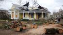Sisa-sisa pohon tumbang tergeletak di depan rumah yang rusak setelah tornado di Selma, Alabama, Amerika Serikat, 13 Januari 2023. Kantor NWS di Birmingham memperingatkan bahwa "darurat tornado" telah dikeluarkan untuk Autauga County. (AP Photo/Stew Milne)