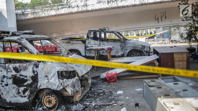 Dua unit mobil polisi usai dibakar massa aksi  unjuk rasa di pos polisi fly over simpang Tomang, Jakarta, Kamis (26/9/2019). Selain menghanguskan pos polisi, api juga membakar belasan sepeda motor dan dua unit mobil polisi yang tengah terparkir di area pos pol Tomang. (Liputan6.com/Faizal Fanani)