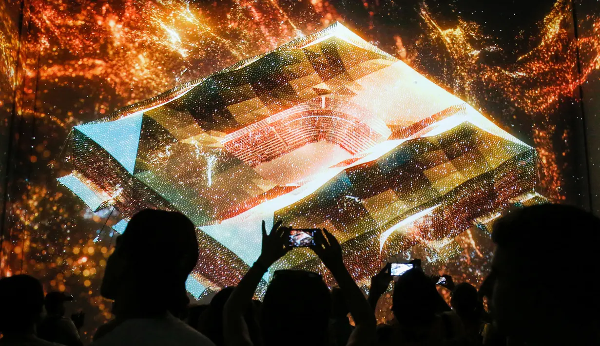 Pengunjung menyaksikan pertunjukan cahaya dalam pameran untuk mempromosikan Piala Dunia 2022 di museum multimedia Qatar Elements, Gorky Park, Moskow, Rusia, Kamis (12/7). (Maxim ZMEYEV/AFP)