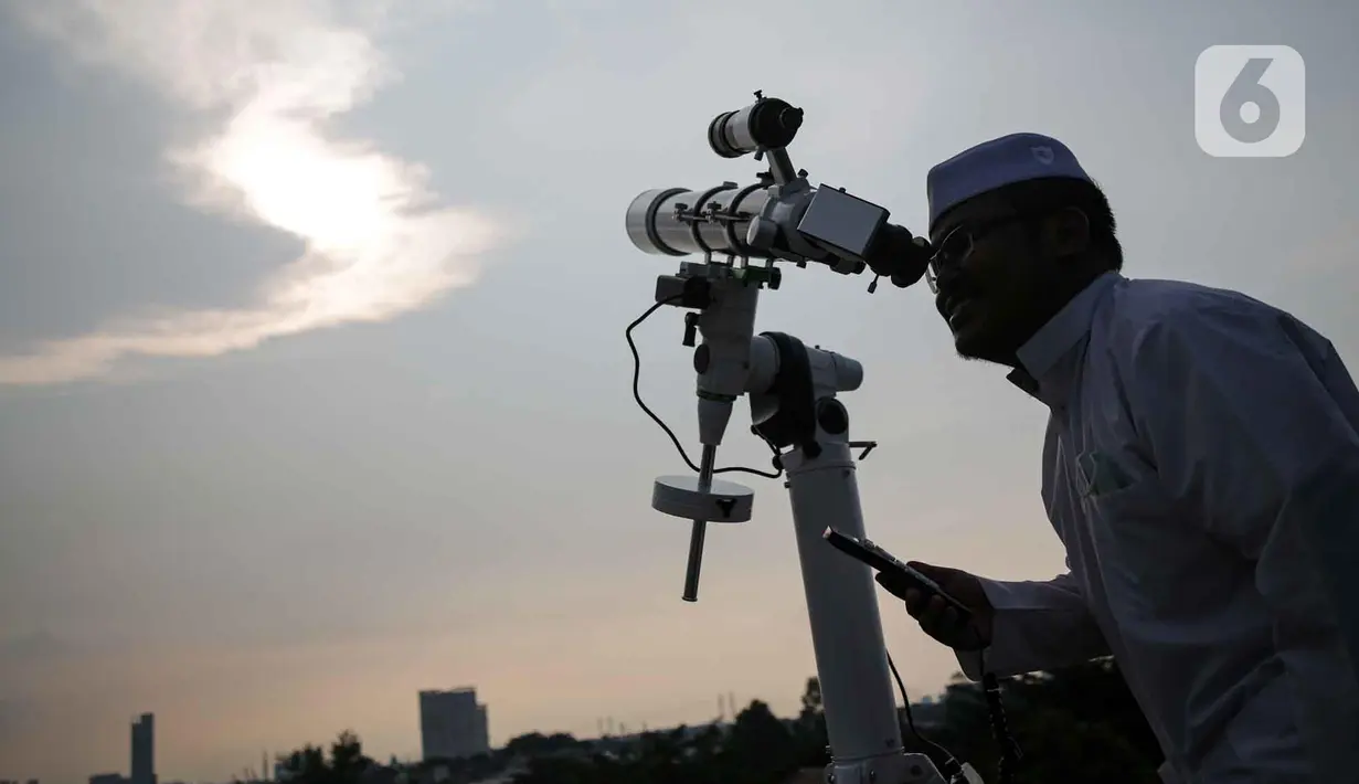 <p>Petugas Masjid Al-Musyariin mengamati posisi hilal menggunakan teropong saat Rukyatul Hilal di Jakarta, Minggu (1/5/2022). Pemantauan hilal yang dilakukan menggunakan teropong tersebut memastikan Idul Fitri 1443 H jatuh pada 2 Mei 2022. (Liputan6.com/Faizal Fanani)</p>