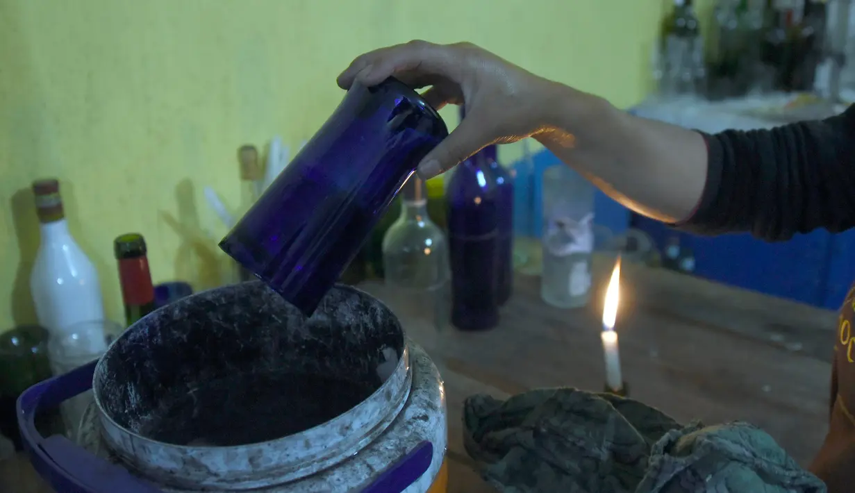Botol yang sudah terpotong dikumpulkan dalam sebuah wadah, Guatemala (12/2). Dengan peralatan sederhana, mereka menyulap botol-botol tersebut menjadi gelas dan vas yang laris dijual di supermarket. (AFP PHOTO/JOHAN Ordonez)