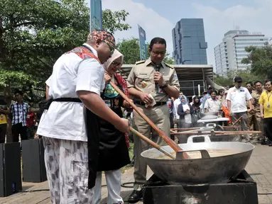 Gubernur DKI Jakarta Anies Baswedan menyaksikan istri Fery Farhati dan chef Ragil memasak salah satu menu olahan daging kurban saat peluncuran Dapur Kurban di Monas, Jakarta, Senin (12/8/2019). (merdeka.com/Iqbal S. Nugroho)