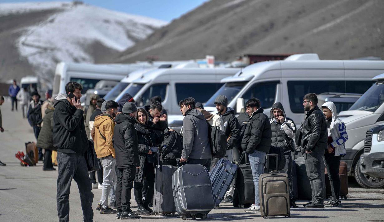 Pergerakan warga ini terjadi di tengah meningkatnya serangan gabungan Amerika Serikat dan Israel terhadap Iran. Tampak dalam foto, warga negara Iran menunggu bus di Turki setelah melewati perbatasan Kapikoy/Razi di Provinsi Van, Turki timur laut, pada Selasa 3 Maret 2026, sehari setelah kedua negara tersebut secara bersama-sama menangguhkan penyeberangan harian di perbatasan mereka karena serangan Israel-Amerika Serikat yang terus menghantam wilayah Republik Islam tersebut. (Ali IHSAN OZTURK/AFP)