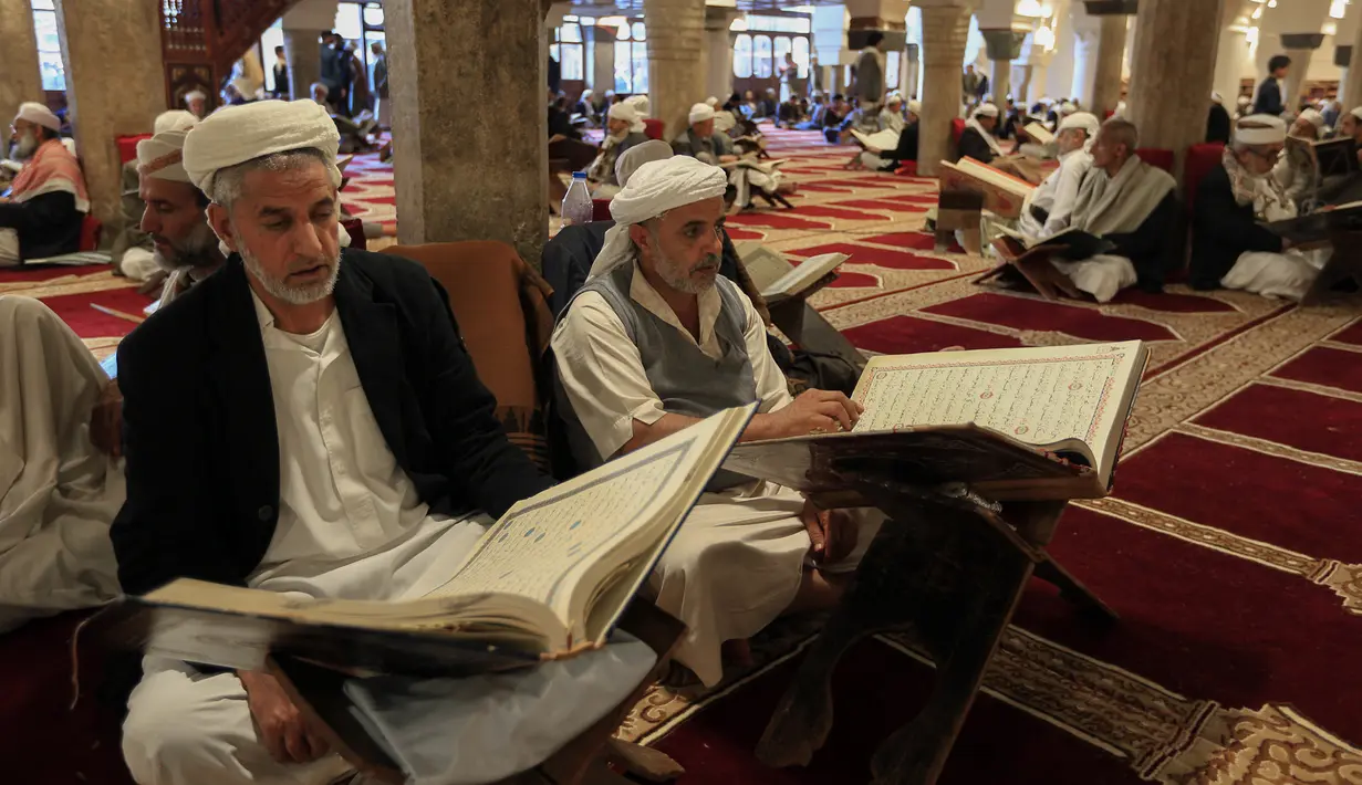 Sejumlah pria membaca Al-Quran selama bulan Ramadan di Masjid Agung Sanaa, Yaman, Minggu (26/4/2020). Kaligrafi dan dekorasi merupakan kekhasan Masjid Agung Sanaa. (Mohammed HUWAIS/AFP)