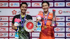 Tunggal putra Indonesia, Anthony Ginting, naik podium bersama tunggal Jepang, Kento Momota, pada BWF World Tour 2019 di Tianhe Gymnasium, Guangzhou, Minggu (15/12). Ginting kalah 21-17, 17-21 dan 14-21 dari Momota. (AFP/STR)