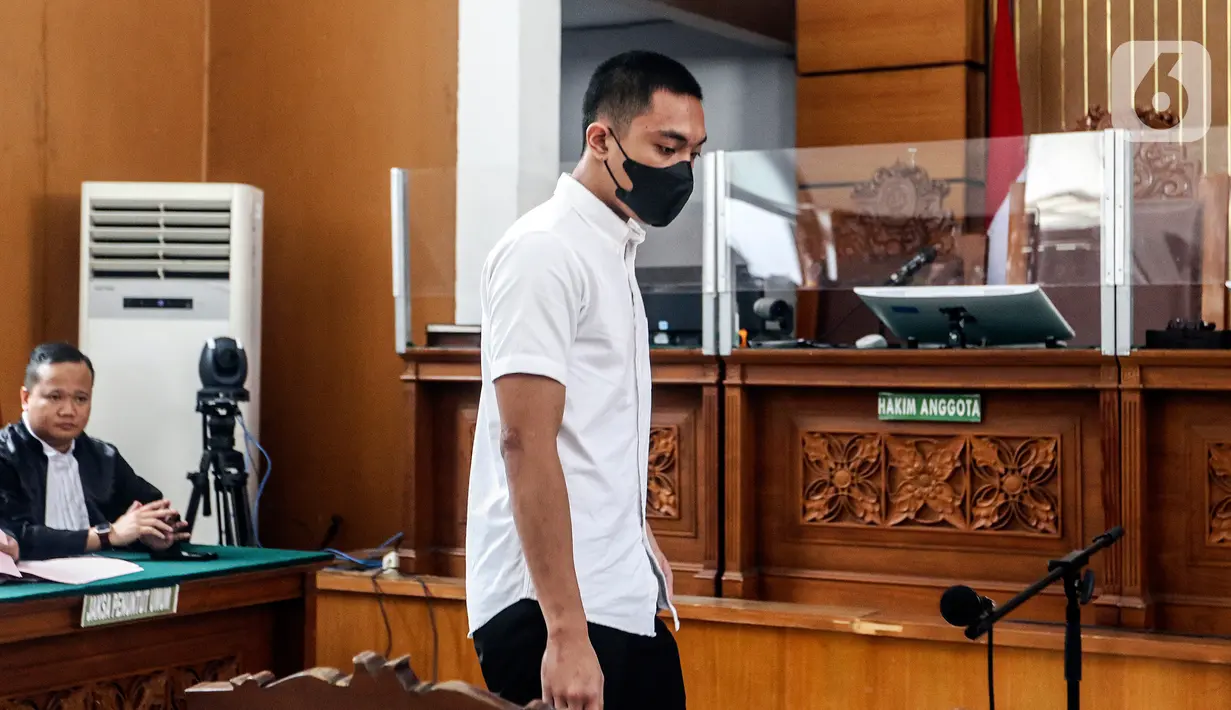 Berbeda dengan Shane yang hanya beralas sendal jepit, Mario justru menggunakan sepatu pantofel hitam. Tangan Mario dan Shane terborgol. (Liputan6.com/Johan Tallo)