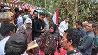 Menteri Sosial Tri Rismaharini membagikan sarung kepada Suku Anak Dalam (SAD) kelompok Tumenggung Nyenong di Kejasung, Batanghari, Jambi, Selasa (20/8/2024). (Liputan6.com/Gresi Plasmanto)