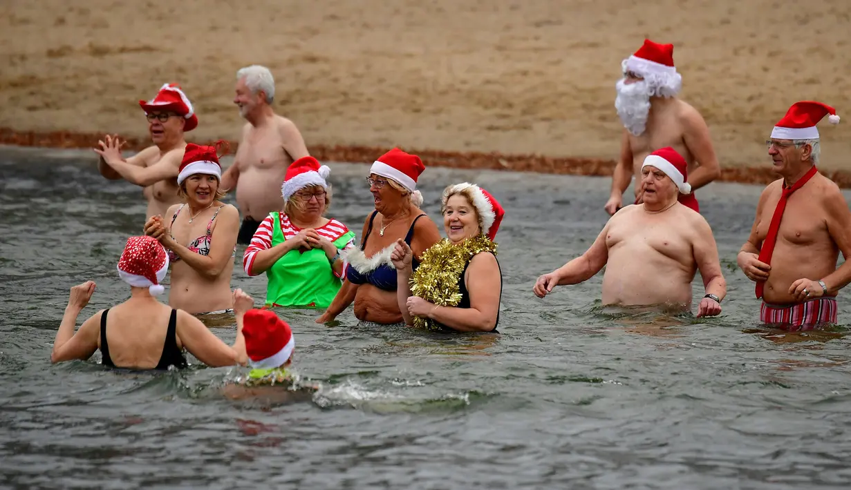Para anggota klub renang "Berliner Seehunde" (Berlin Seals) berendam di Danau Orankesee yang dingin di Berlin, Jerman, Senin (25/12). Berenang di danau itu salah satu tradisi masyarakat Berlin menyambut Natal setiap tahun.(Tobias SCHWARZ/AFP)