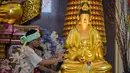 Dalam prosesinya, patung dibersihkan menggunakan air yang telah dicampur dengan berbagai jenis bunga, seperti sedap malam, mawar, dan melati. Tampak dalam foto, seorang pria membersihkan patung Buddha sebagai persiapan perayaan Tahun Baru Imlek 2577 Kongzili di Vihara Buddhayana, Surabaya, Jawa Timur pada Senin 9 Februari 2026. (JUNI KRISWANTO/AFP)