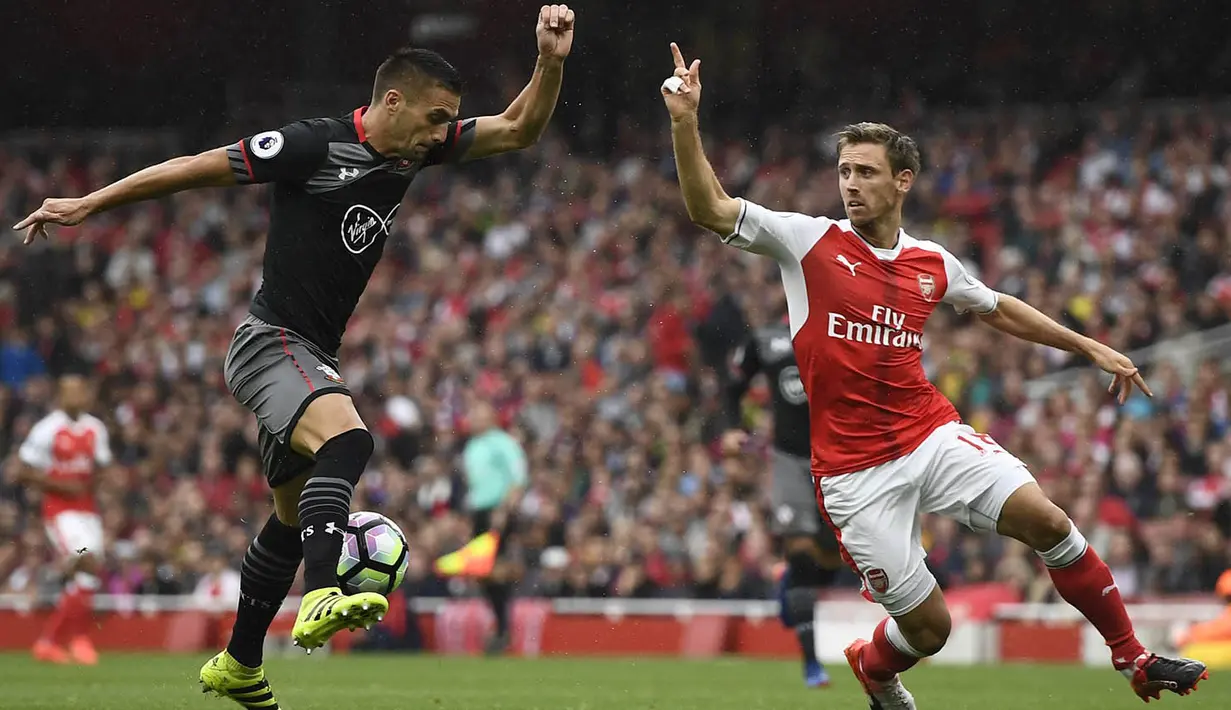 Bek Arsenal, Nacho Monreal, berusaha menahan laju penyerang Southampton, Dusan Tadic. Pada laga ini Arsenal memakai formasi 4-3-2-1, sementara Southampton menggunakan skema 4-3-3. (Reuters/Dylan Martinez)
