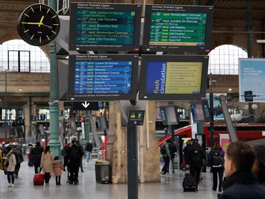Sejumlah pelancong berjalan melewati layar informasi saat lalu lintas terganggu di stasiun kereta Gare du Nord pada hari kedua pemogokan nasional dan protes terhadap rencana reformasi pensiun pemerintah di Paris, Selasa (31/1/2023). Prancis bersiap-siap menghadapi gangguan transportasi utama, dengan pemogokan massal dan protes yang akan melanda negara tersebut untuk kedua kalinya. (Ludovic MARIN/AFP)