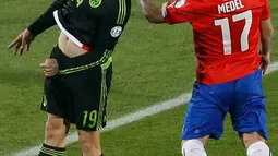 Penyerang Meksiko, Vicente Vuoso berebut bola udara dengan bek Chile Gary Medel saat pertandingan Copa America 2015 di National Stadium, Santiago, Chile, (16/6/2015). Chile bermain imbang 3-3 dengan Meksiko. (REUTERS/Carlos Garcia Rawlins)