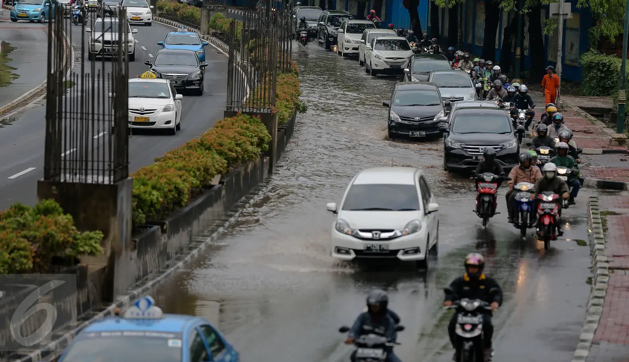 Sejumlah kendaran melintas di Kawasan Kuningan, Jakarta, Selasa (24/11). Jalur lambat di Jalan HR Rasuna Said, Kuningan, tampak dihindari oleh pengendara karena terdapat genagan air setinggi 20 cm. (Liputan6.com/Faizal Fanani)