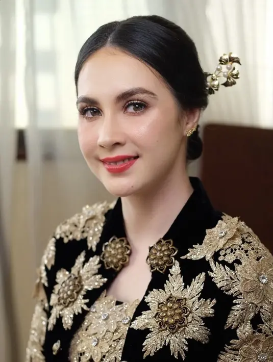 MUA Fatricia Ariane memoles wajah Arumi dengan makeup soft glam. Mengaplikasikan lipstik merah cherry, dengan blush on pink tipis. [@fatriciaariane]